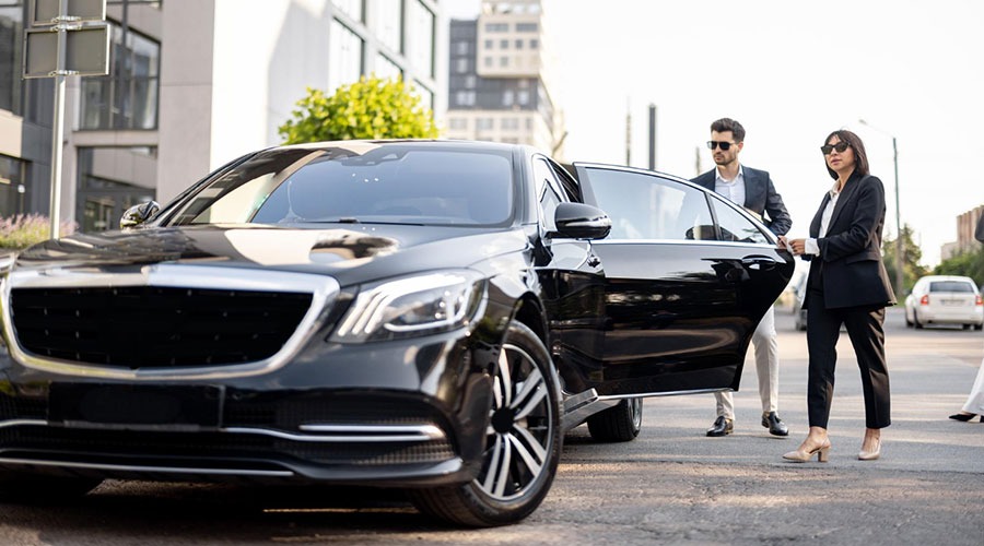 Chauffeur beside black car